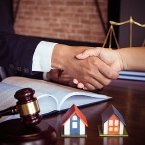 Handshake between a real estate agent and a client in an office setting.