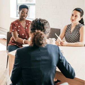 Real estate agent discussing property details with clients in an office setting.