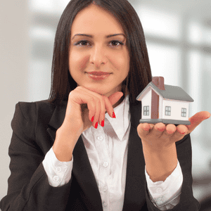Real estate agent showcasing a small house model for home selling.