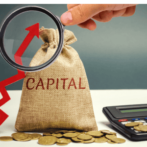 Magnifying glass over a money bag with 'CAPITAL' and coins.