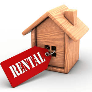 Wooden house model with rental tag for property sale or lease.
