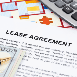 Lease agreement document with a calculator and house plans.