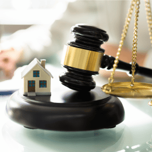 Gavel, house model, and scales of justice for property law.