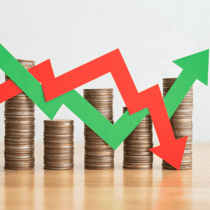 Stacked coins with red and green arrows showing decline and growth.