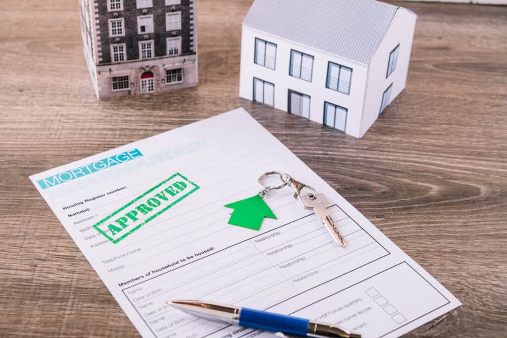 Property approval document with house models and keys for real estate.