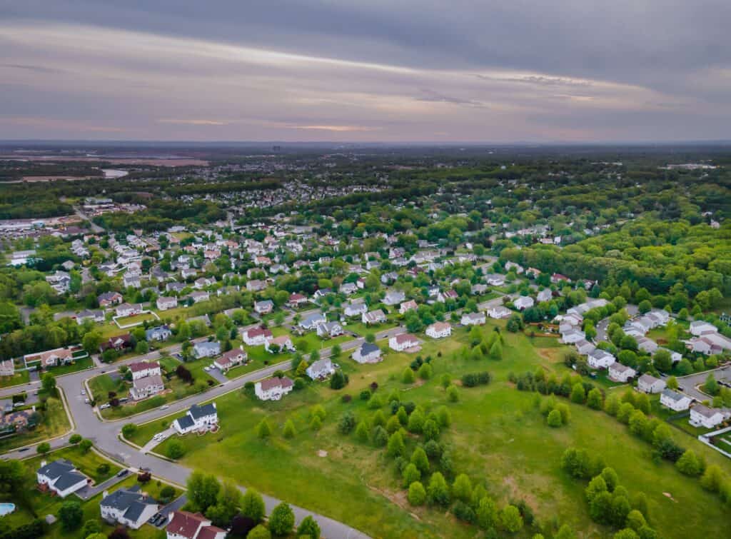 Aerial view of a suburban neighborhood with green spaces and houses.